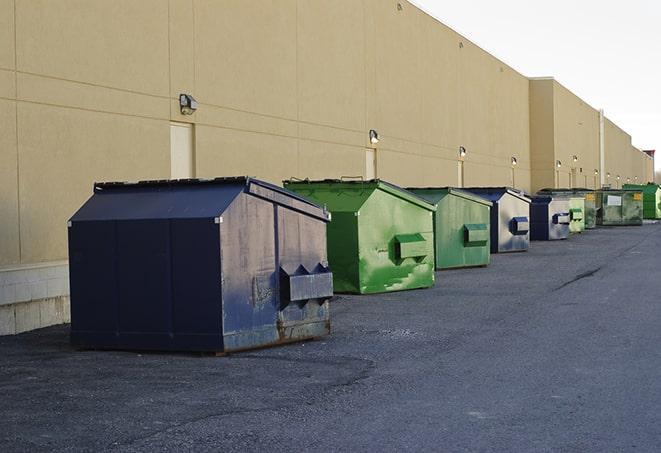 a compact construction dumpster being emptied by a waste disposal truck in Bixby